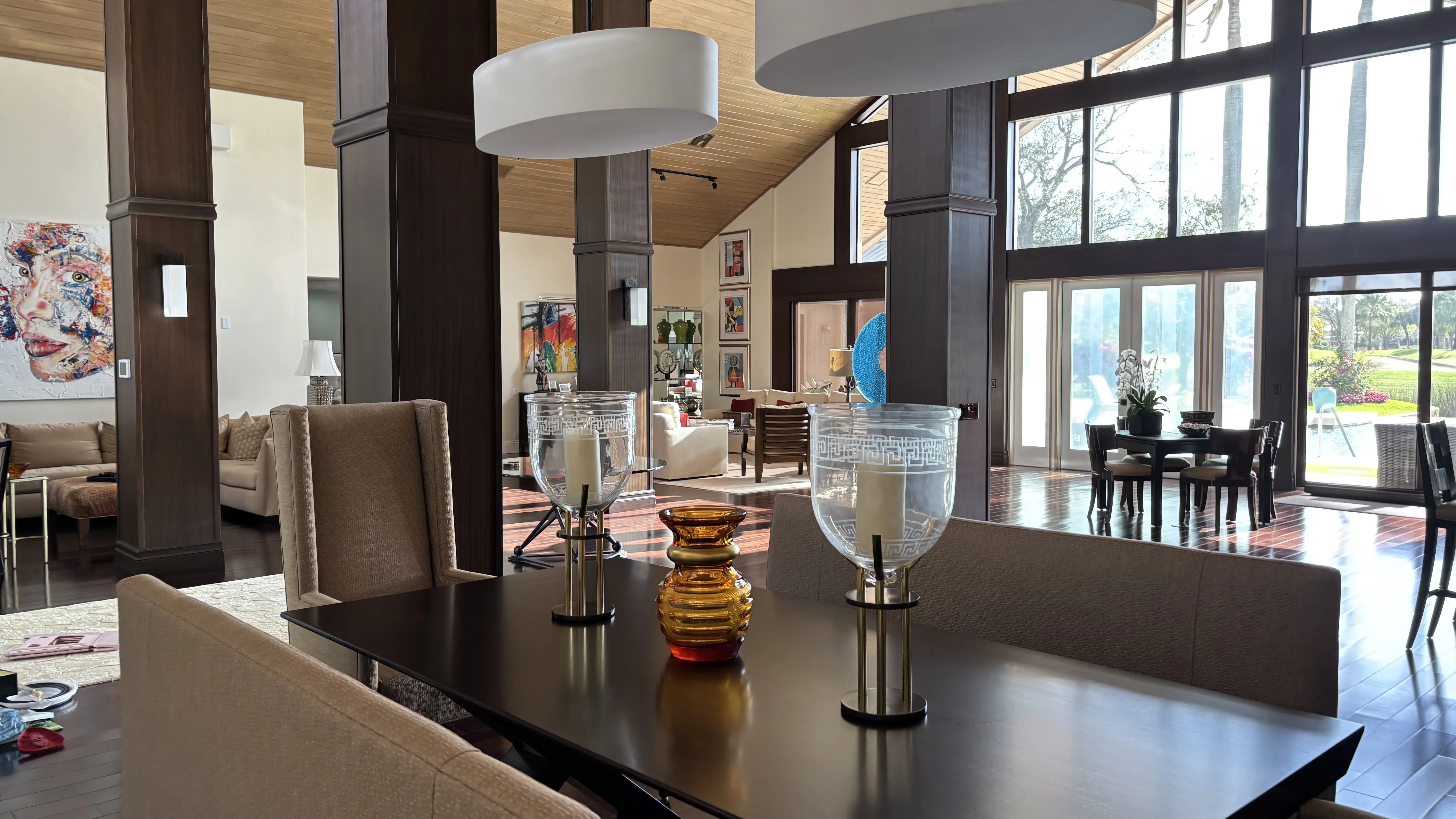Modern living space with dining table, large windows, and stylish decor.