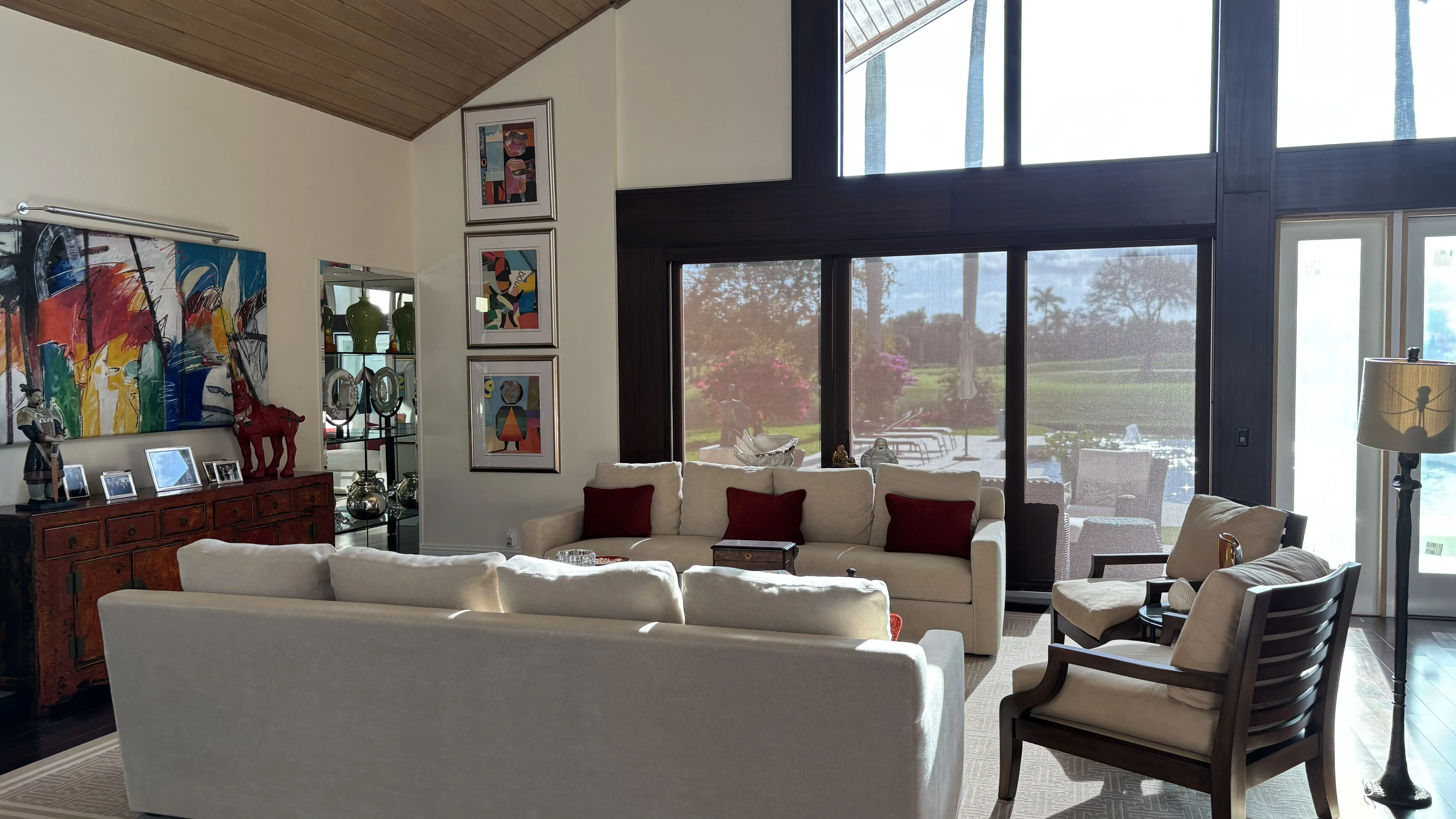 Bright, modern living room with large windows, artwork, and comfortable furniture.